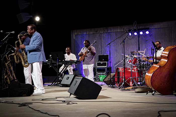 Black jazz musicians play at the outdoor amphitheater.